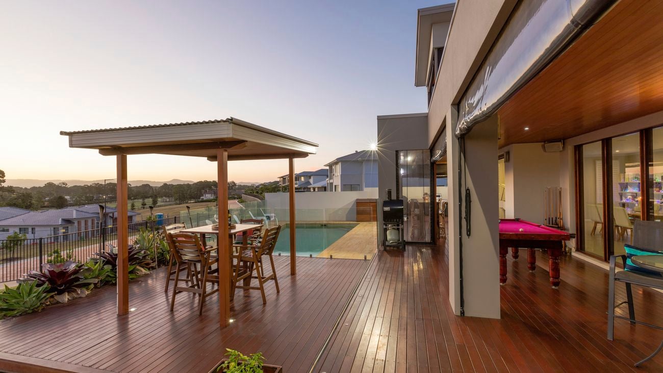 Backyard patio setting with swimming pool at sunset in luxury home 