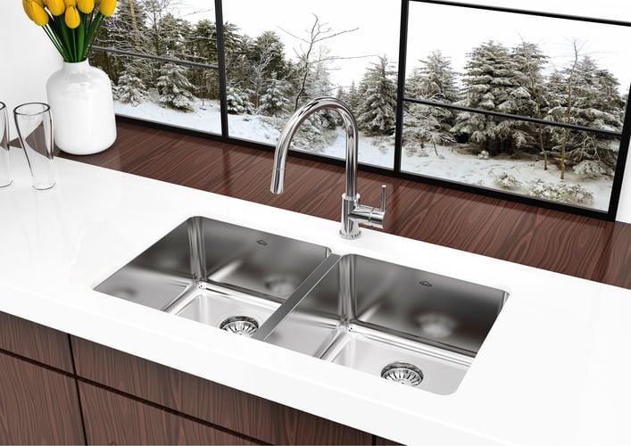 White kitchen benchtop with stainless steel sink and tapware