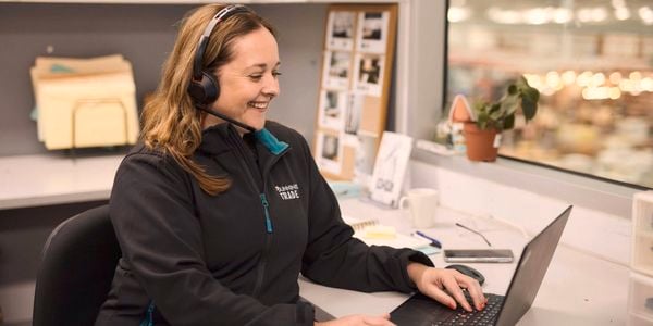 A Bunnings Team Member sitting at a desk with a laptop in front of them.