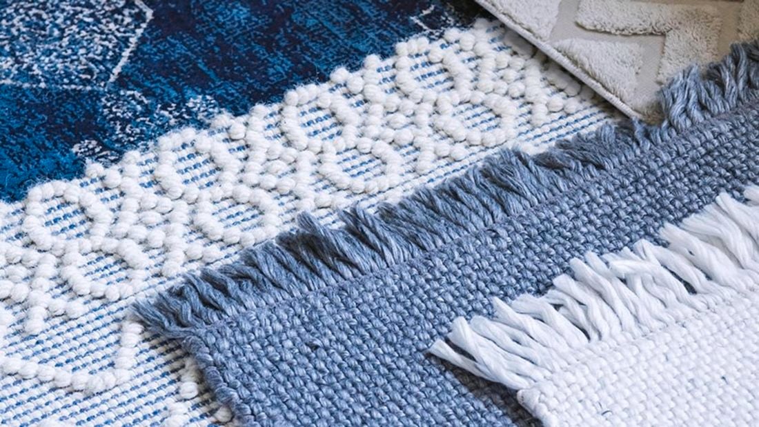 Close up of a white and blue textured rug.