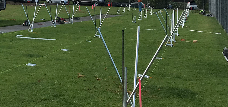 Steel base plates and poles arranged on a grassed area