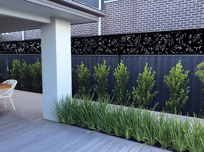 Fence between neighbours with decorative screening extending the height