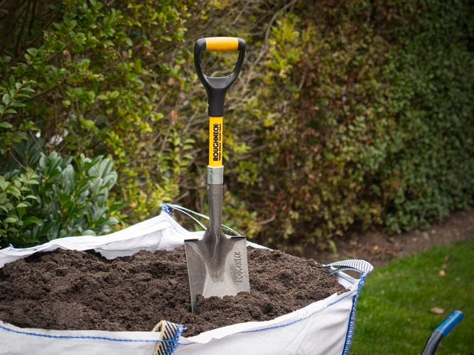 Roughneck Micro Square Shovel standing in soil inside a bulk bag.