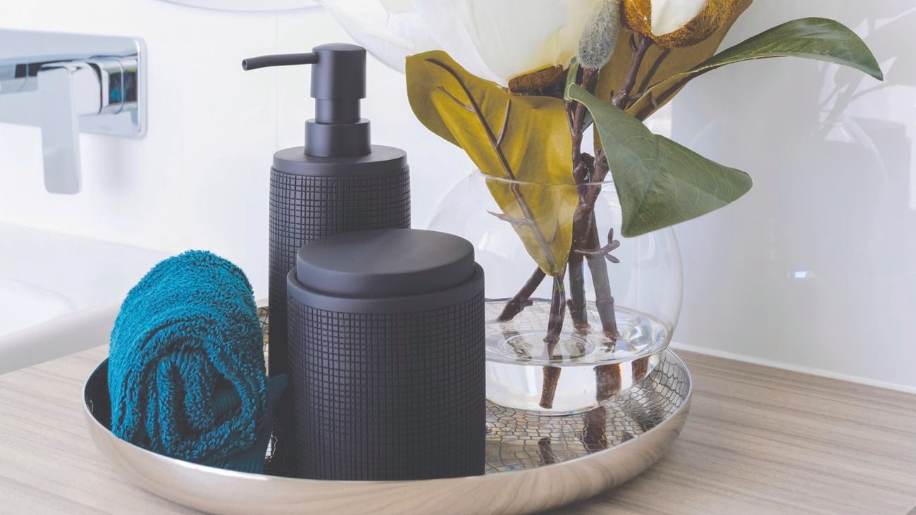 Artificial flowers on countertop with soap.