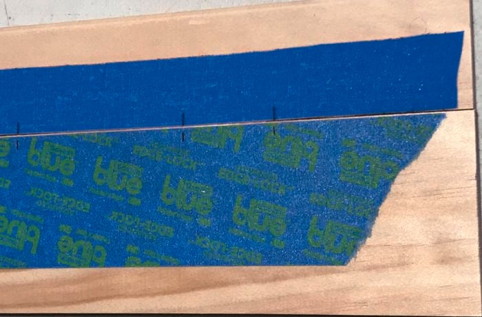Two lengths of timber with measurements marked on masking tape 
