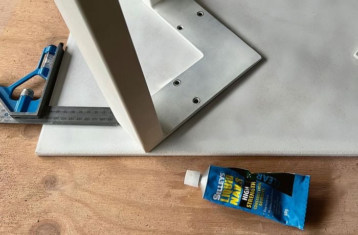 A combination square used on the base of a white side table