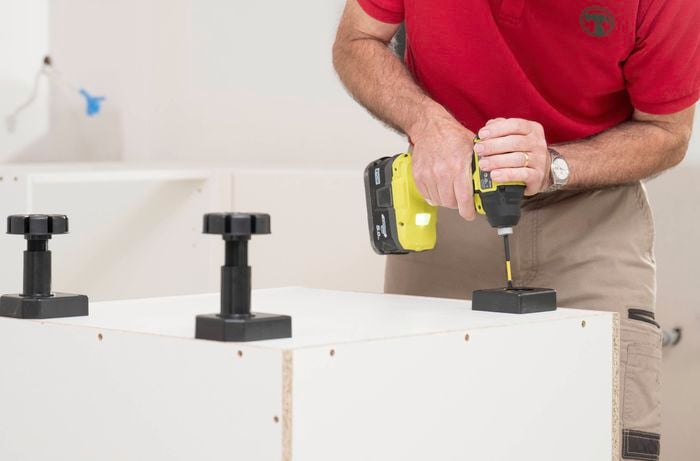 Install the adjustable feet  to the bottom of the base panel 
