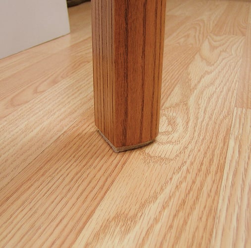 Base of table leg with floor surface protection adhesive