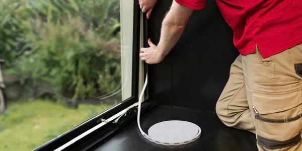 Person installing weather seal for a window