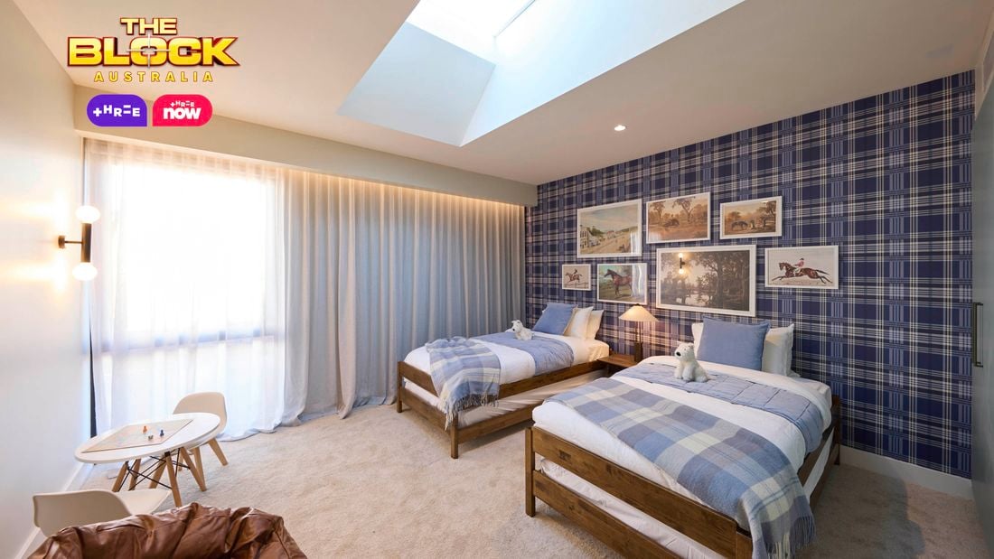 Blue bedroom with a check wallpapered wall and twin beds with blue linens. Opposite is a brown leather bean bag and small kids table. Above the beds are various horse artworks arranged sporadically.
