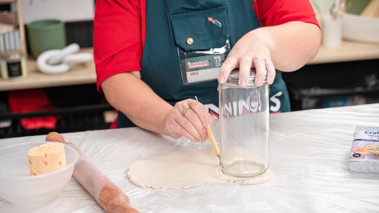 A bunnings team member cutting out candle holder base.