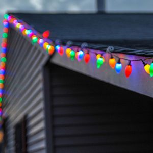 Colourful string lights attached to roof gutter.