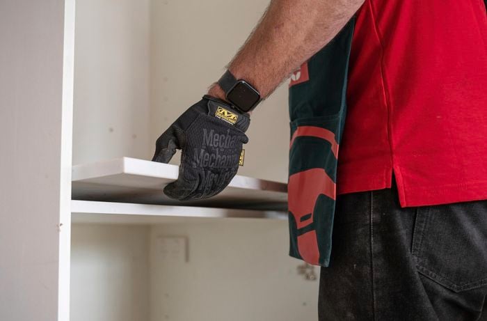 A person holding the benchtop with his hands.