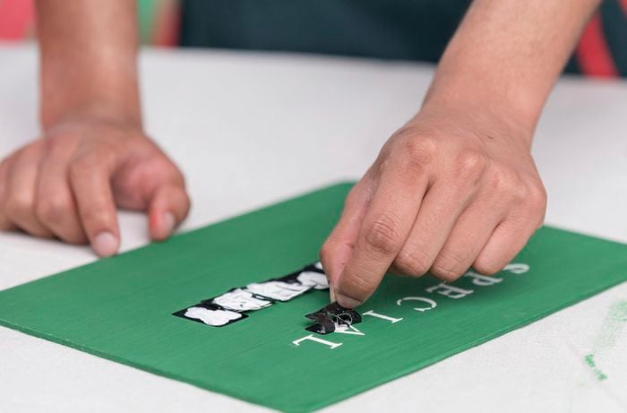 A Bunnings Team Member taking film off a letter on a board