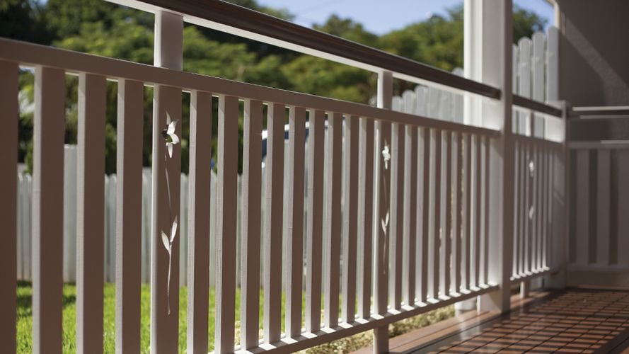 Close up of an exterior wooden balustrade painted white