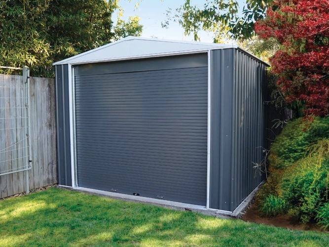A shed located in a corner of a backyard.