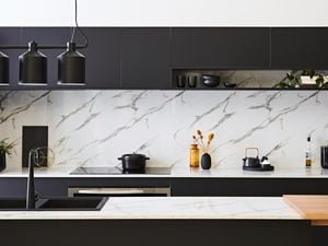 Grey Marble-walled bathroom with a sink, toilet and shower.