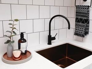 a black tap and a sink on a modular benchtop