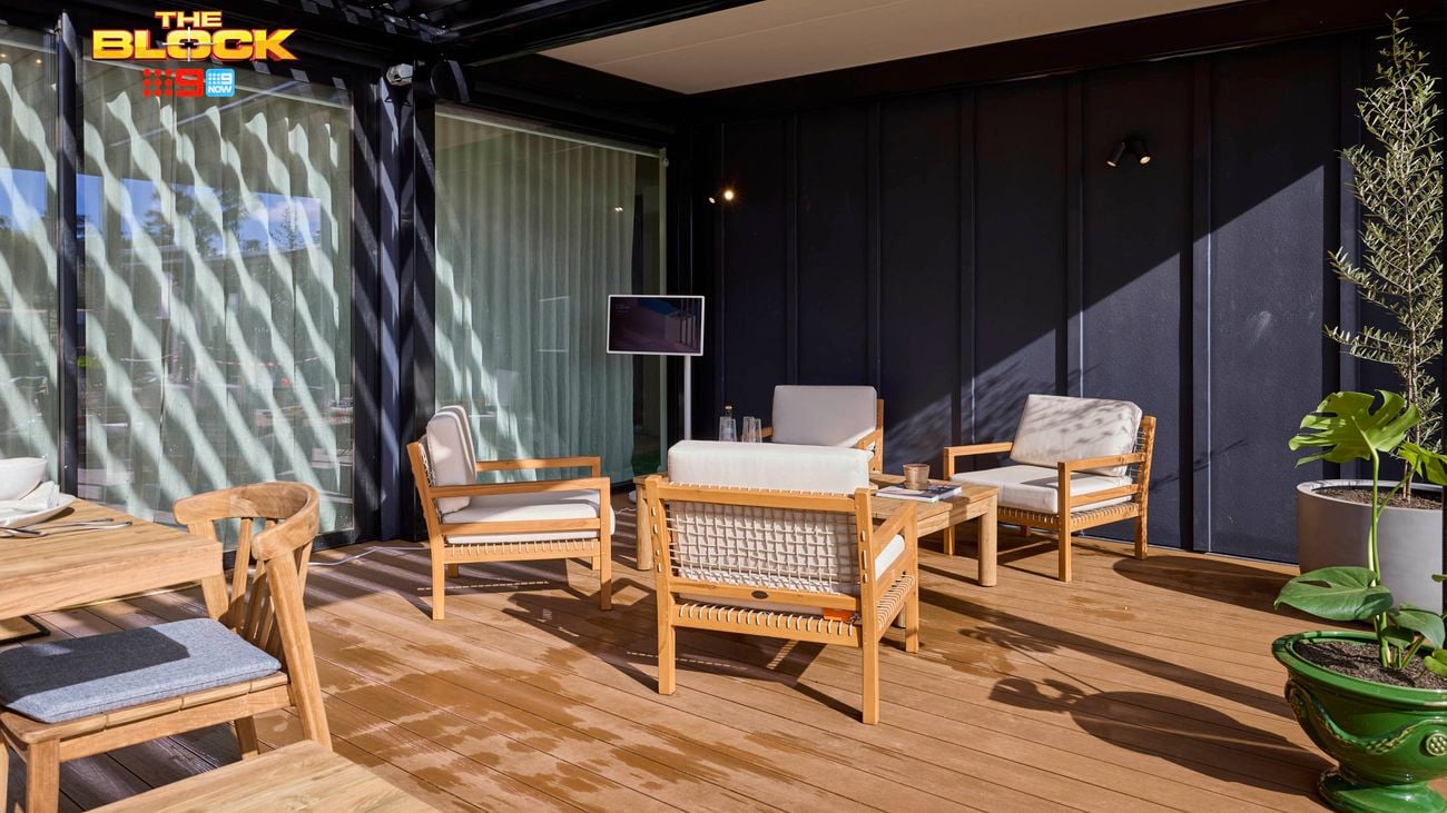 Outdoor area with a table and chairs in it on decking.