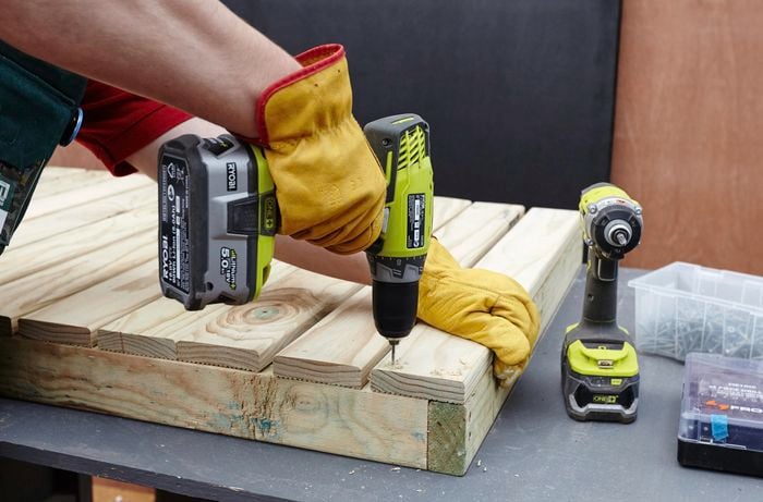 Person drilling timber slats to a frame.