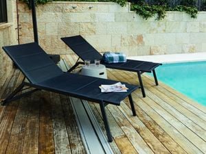 Sunlounges and umbrella placed poolside