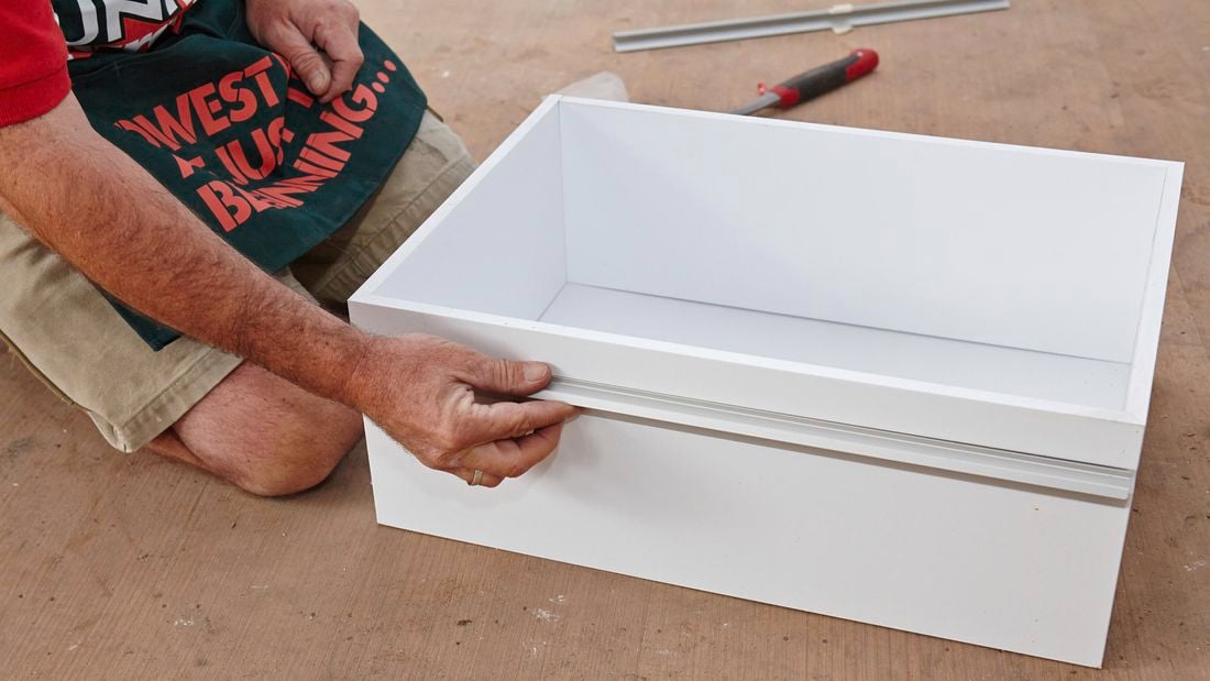 Person putting draw runners in place.