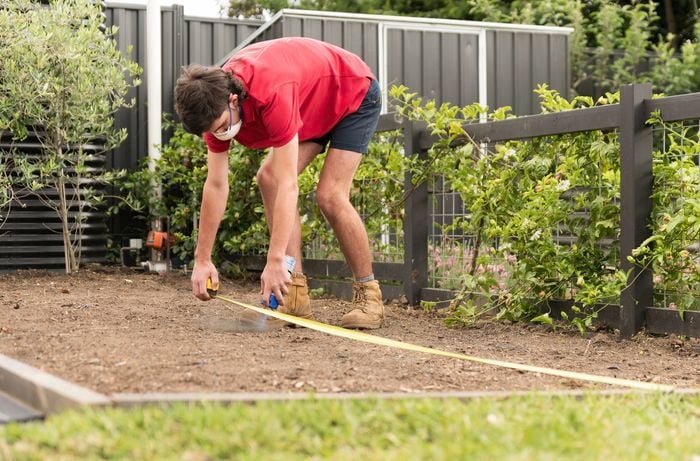 Measure and mark the area with spray paint using a measuring tape 
