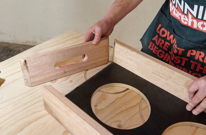 A person fitting a mitred end onto a timber frame