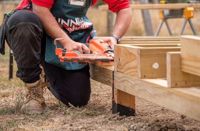 A Bunnings Team Member adding a bracket to a subfloor using a nail gun