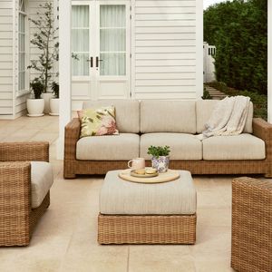 Outdoor patio with wicker sofa, chairs, ottoman, and pet bed.
