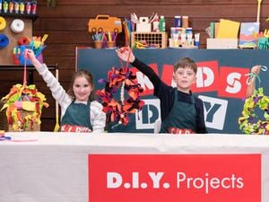 Three kids are holding a beautiful wreath