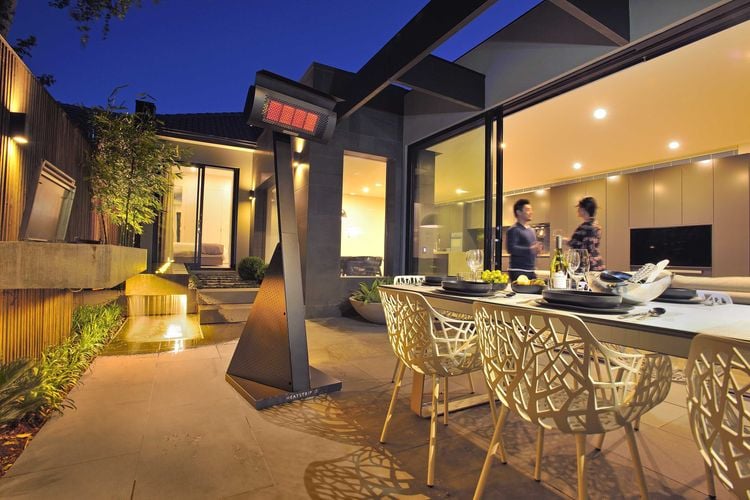 Outdoor dining area with water feature heated by freestanding heat lamp