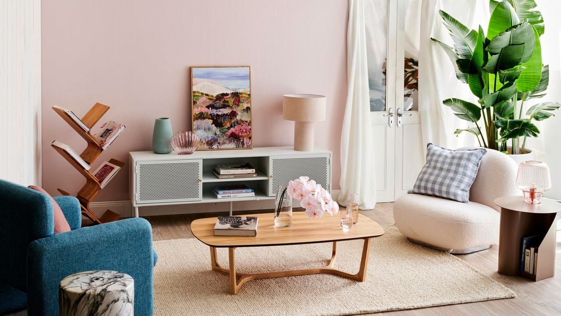 Living room with a cabinet and a lamp in foreground and a painting in background.