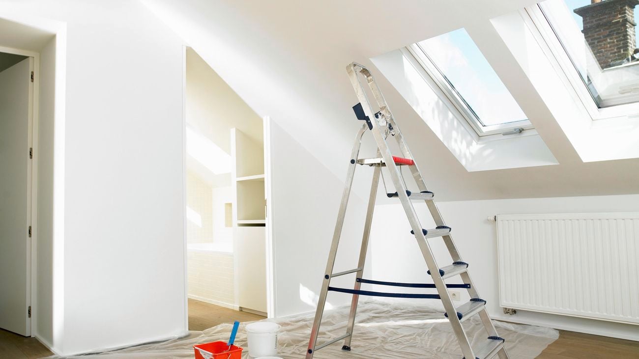 A safety ladder in an attic on a plastic drop sheet