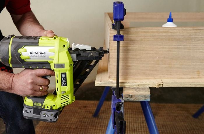 The base frame of a dog bed being assembled with a nailgun