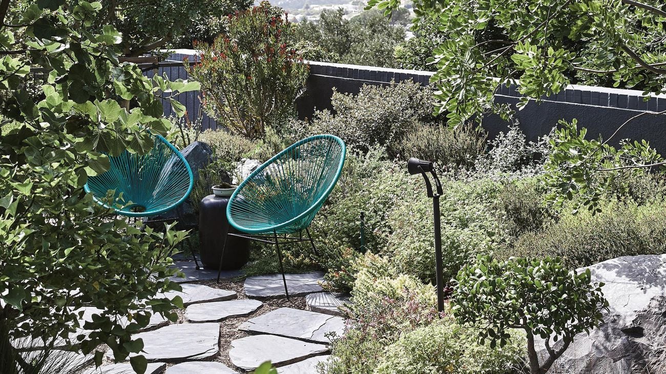 Coastal style landscaping featuring irregular paving stones and drought tolerant plants.