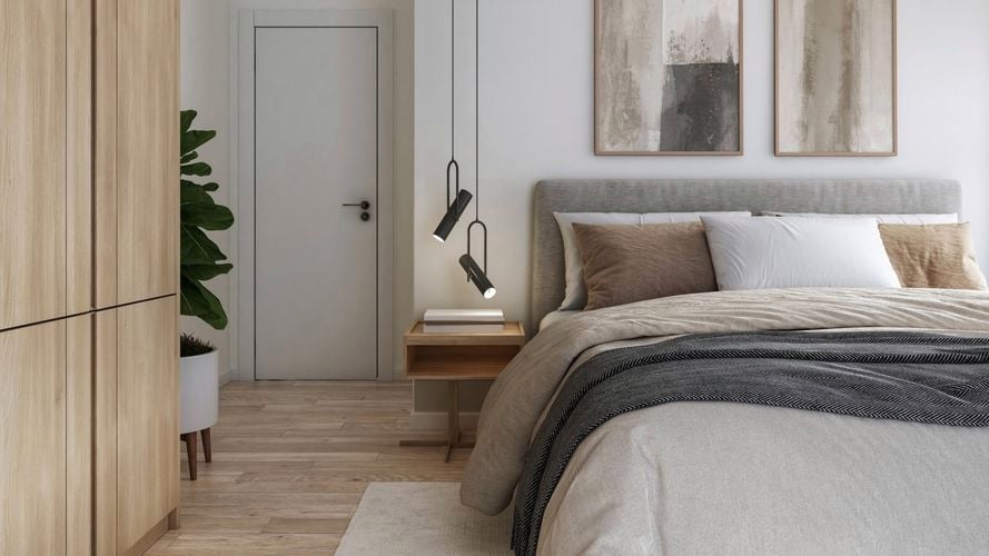 Modern bedroom featuring grey fabric bed, pendant lighting and artwork.