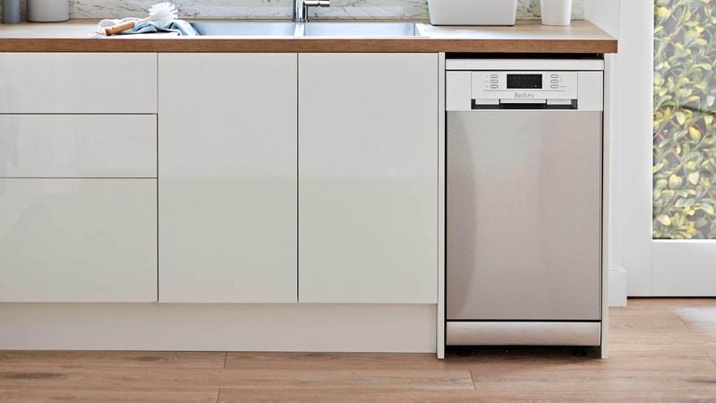 Stainless steel dishwasher in light filled kitchen with scandi style and white cabinetry
