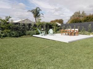 Sprawling green lawn with outdoor furniture.