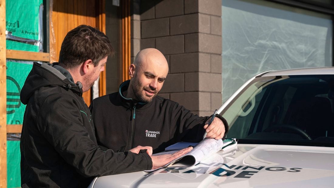 A Bunnings account manager looking at house plans on the hood of this Ute.