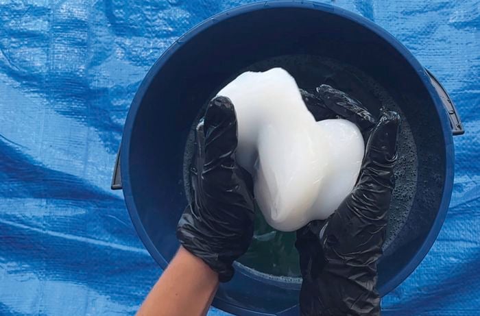 Someone kneading silicone and making sure water has been squeezed out of it.