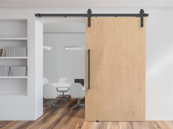 Office interior featuring Rolltrak Matte Black Side Mount Barn Door Track, 600mm Matte Black Square Single Pull Handle and Matte Black Barn Door Guide.
