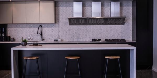 A monochrome themed kitchen with hexagonal tiled walls