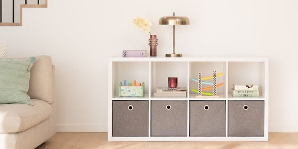 Indoor storage unit with grey boxes that sit under and stairwell. 
