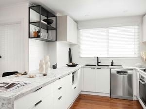 White kitchen with black accents and stone-look benchtops.