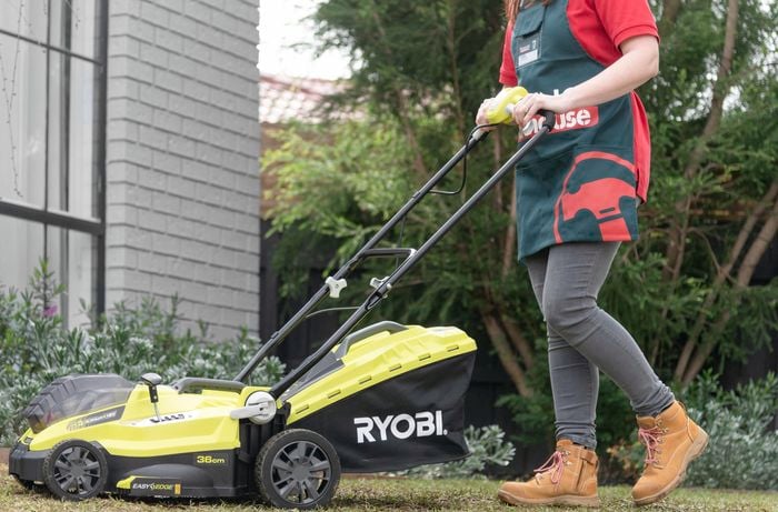 A person mowing a lawn with a lawn mower