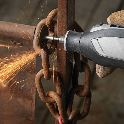 Dremel tool cutting a wooden panel with a rotary blade.
