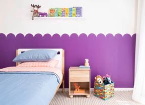 A playful purple scalloped wall feature creates a fun backdrop in a kids bedroom. 