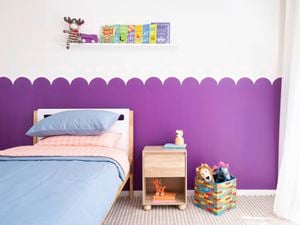 A playful purple scalloped wall feature creates a fun backdrop in a kids bedroom. 