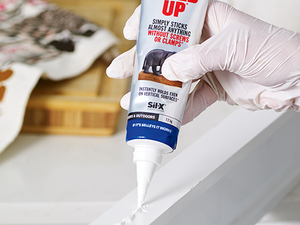 Close-up of someone applying Selleys product to wood